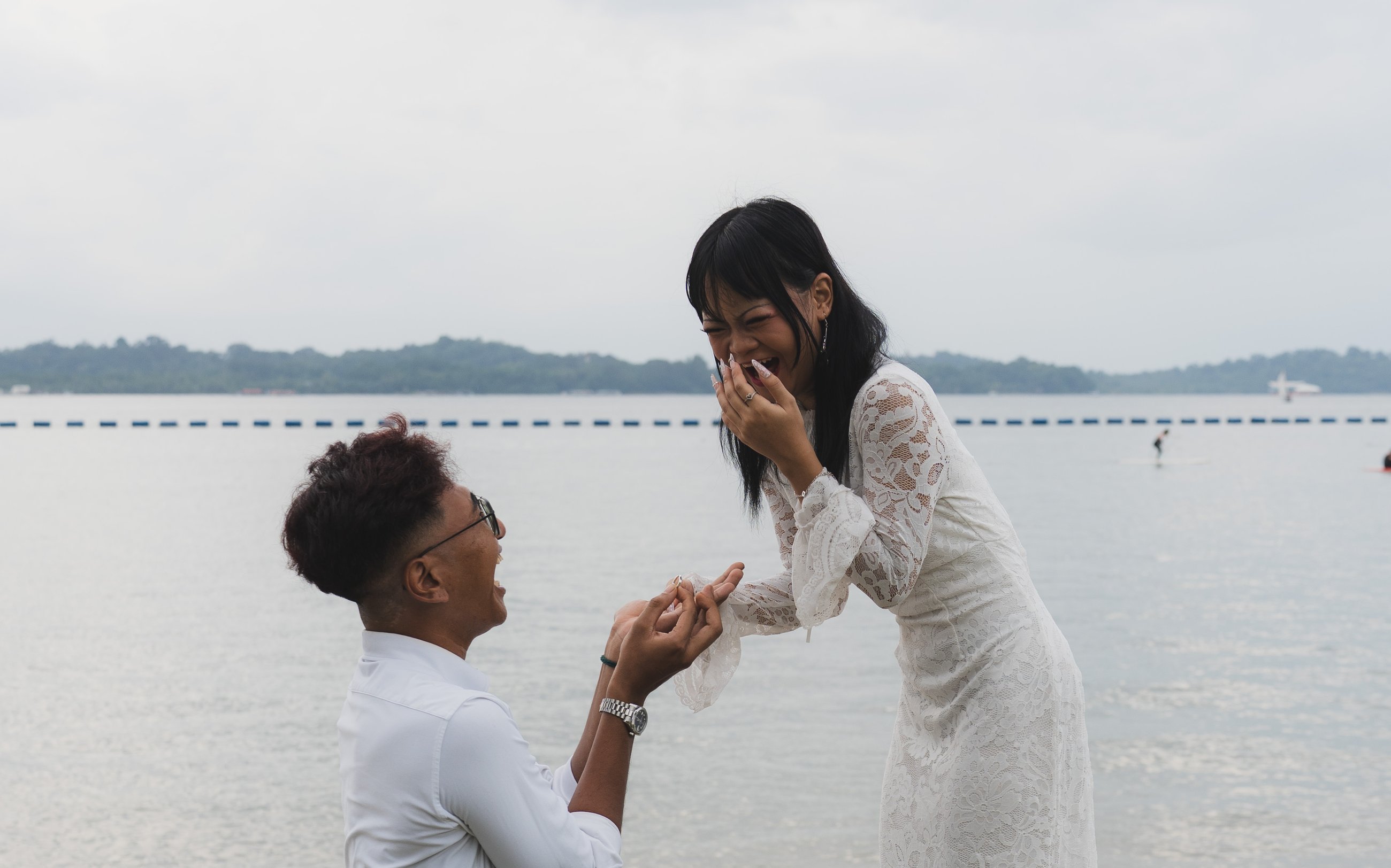 Couple at the water's edge during a proposal, KYO Collective