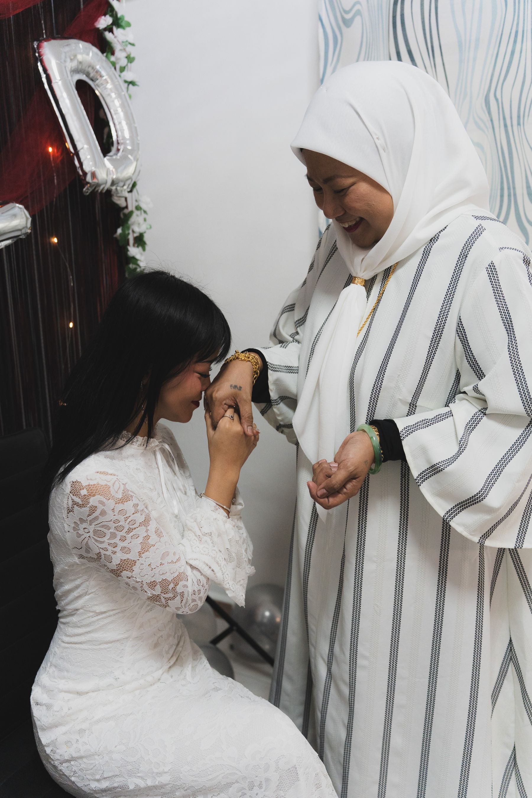 Bride kissing her mother's hand in blessing