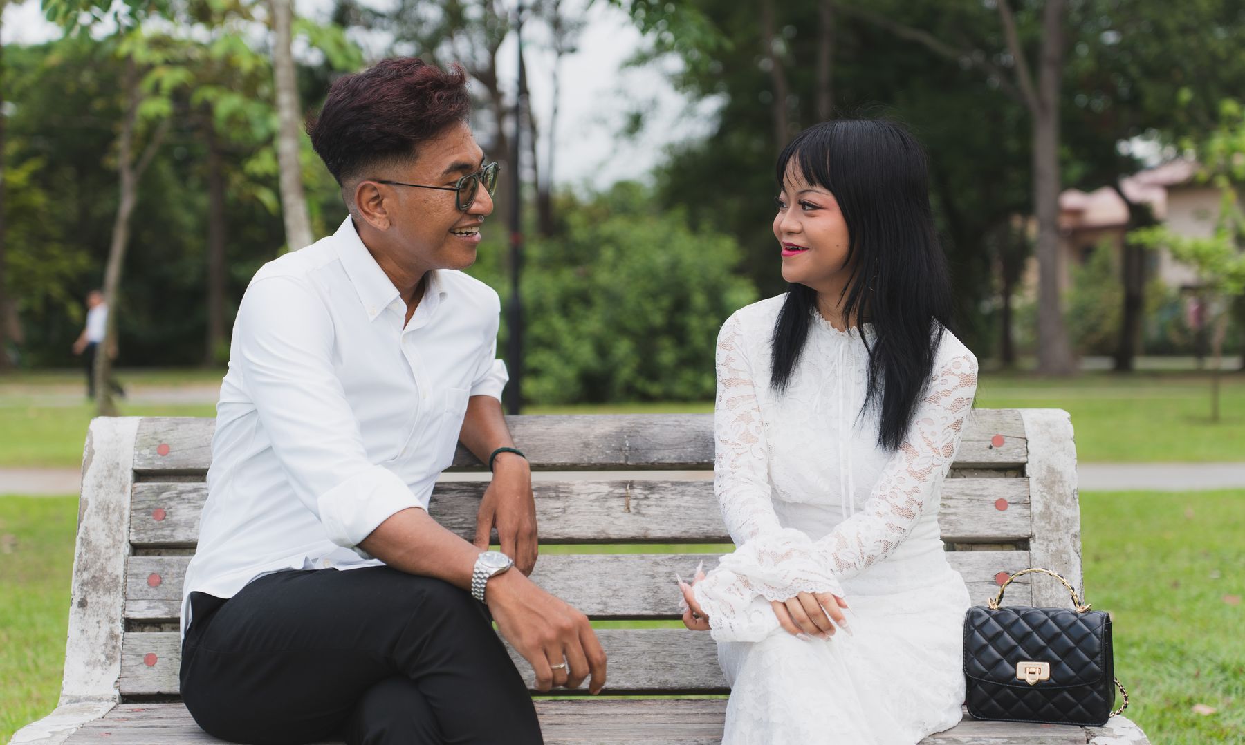 The couple on a park bench, turned toward each other
