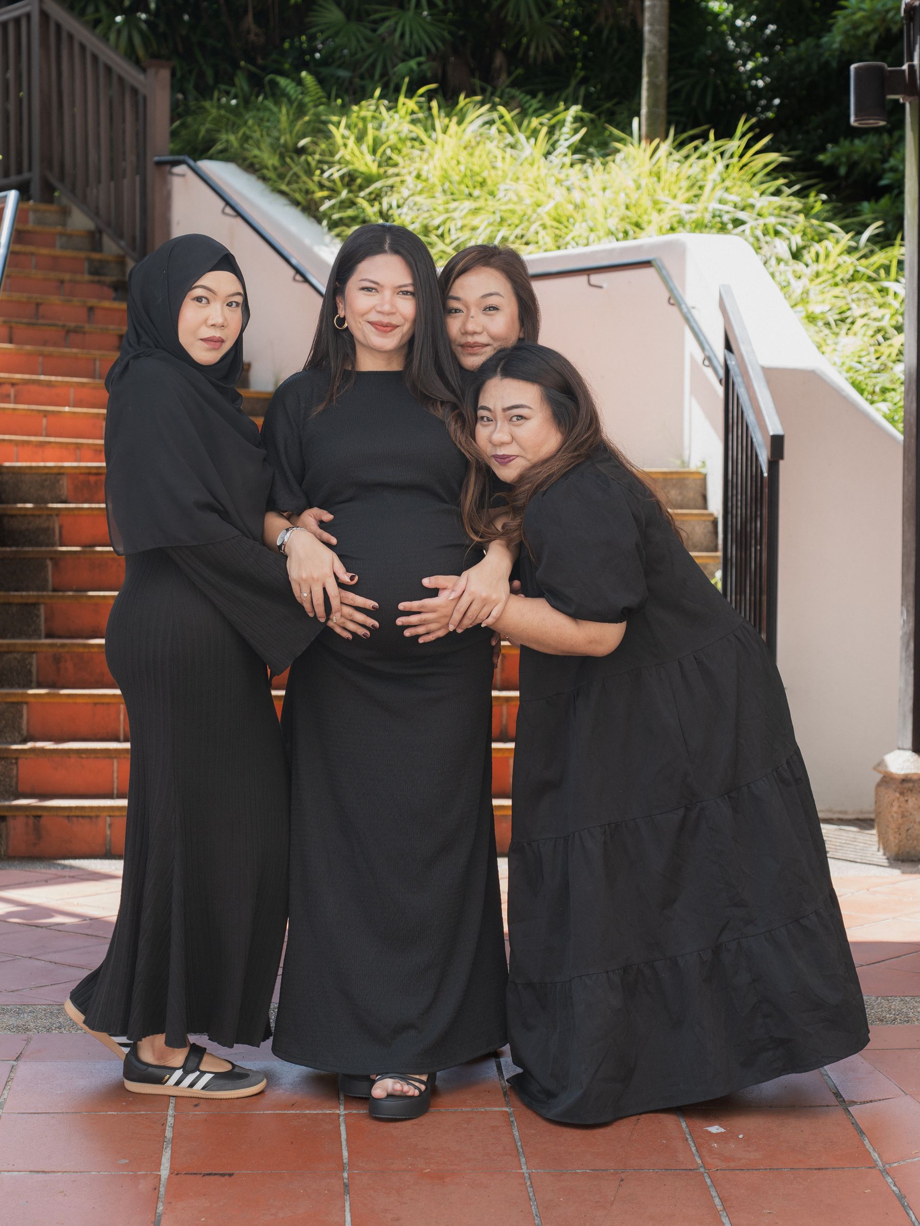 Friends gathered around a pregnant belly in celebration