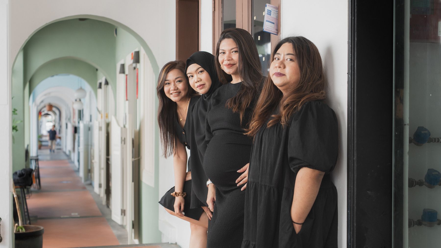 The four of them lined up along a shophouse corridor