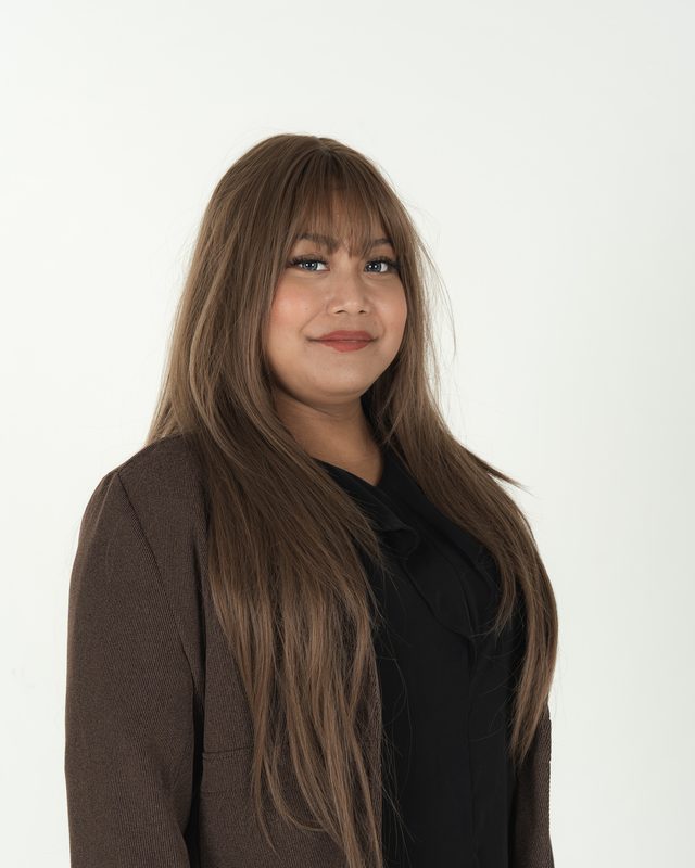 Audadi smiling in a brown blazer, headshot