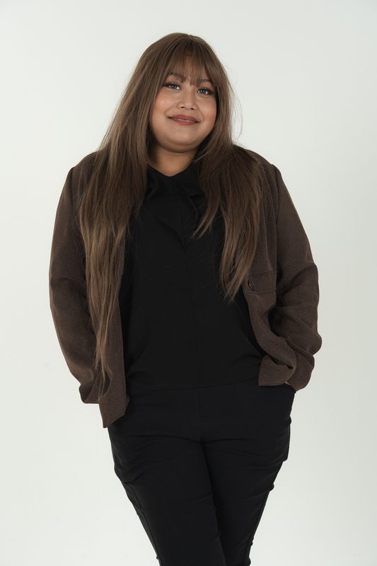 Audadi standing with hands in her blazer pockets