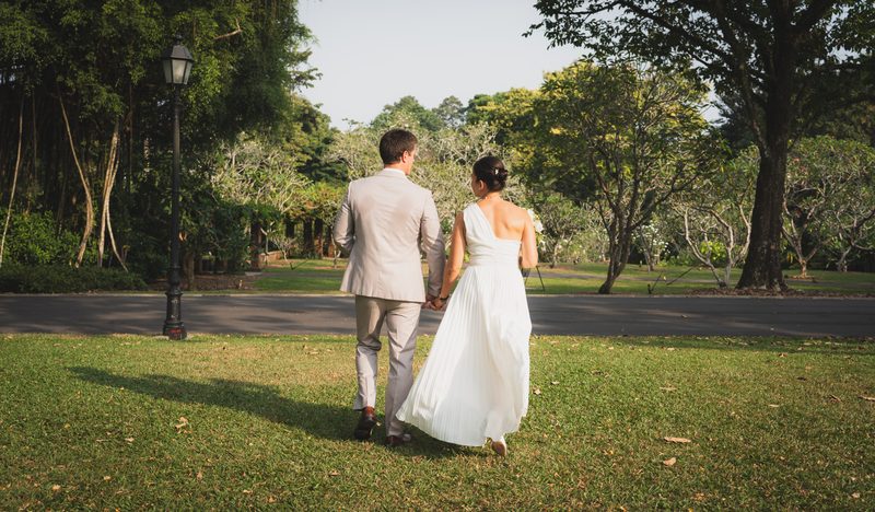 The couple walking across the lawn, seen from behind