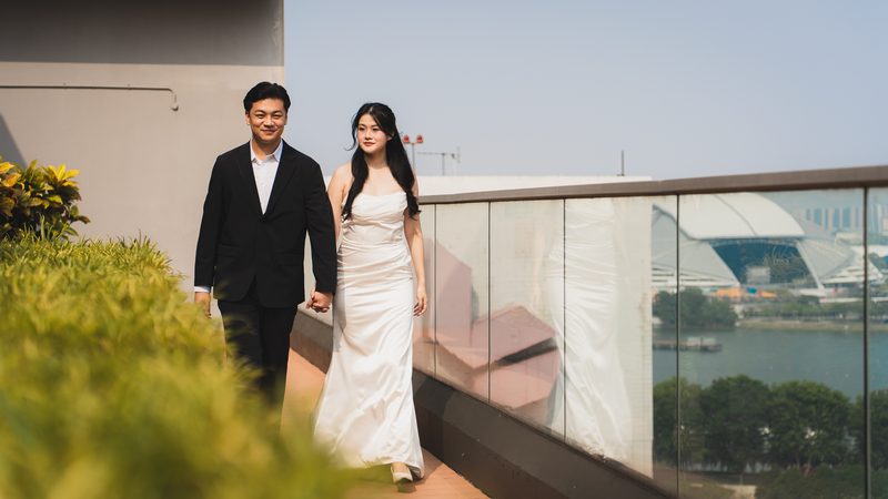 The couple walking along a rooftop above the city