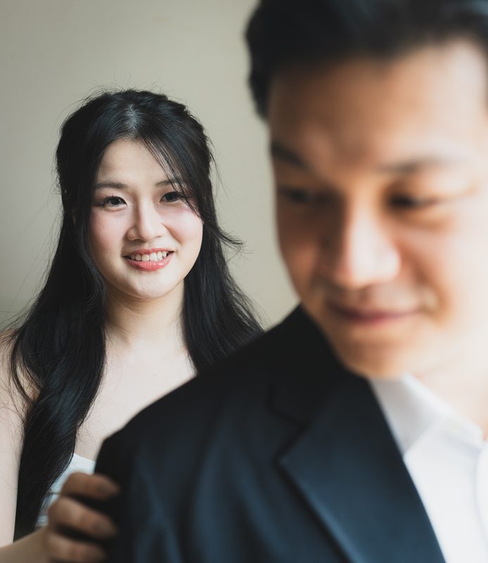 The bride smiling past the groom's shoulder