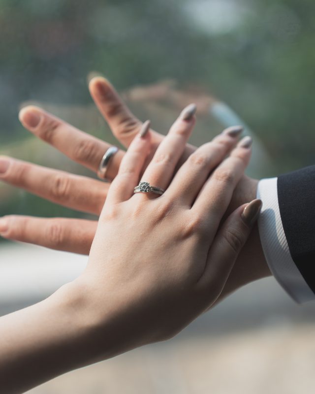 Their hands together, her ring catching the light