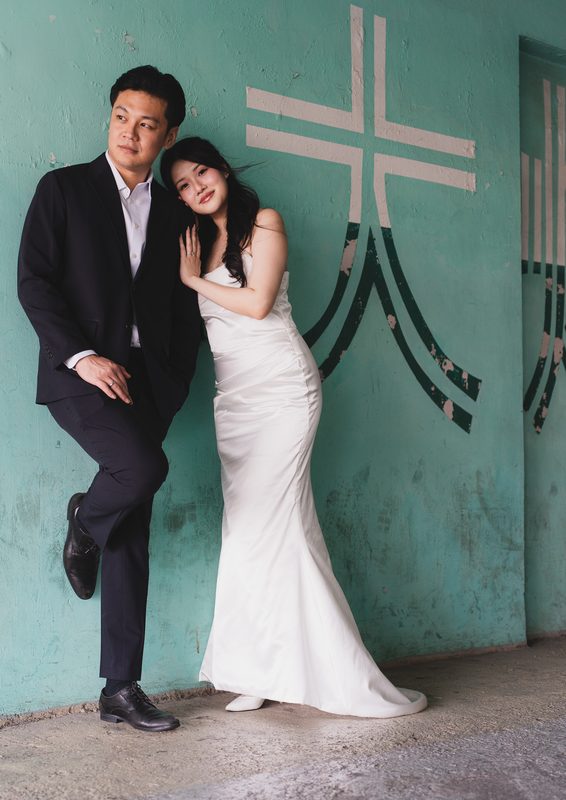 Leaning together against a teal wall