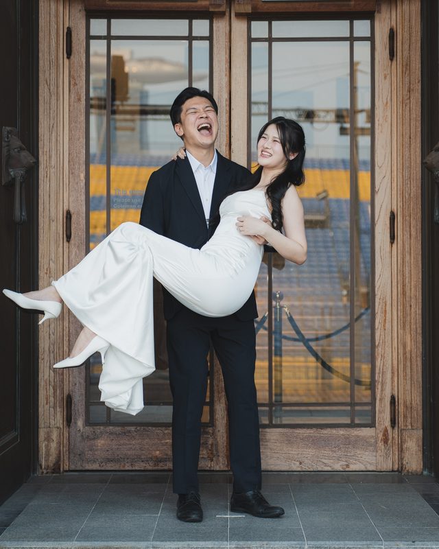 The groom carrying the bride in a doorway, both laughing