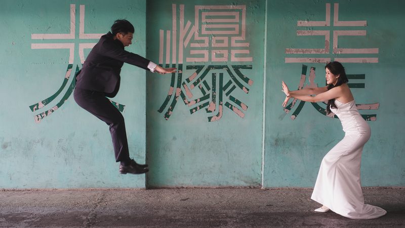 A playful leap in front of a teal wall