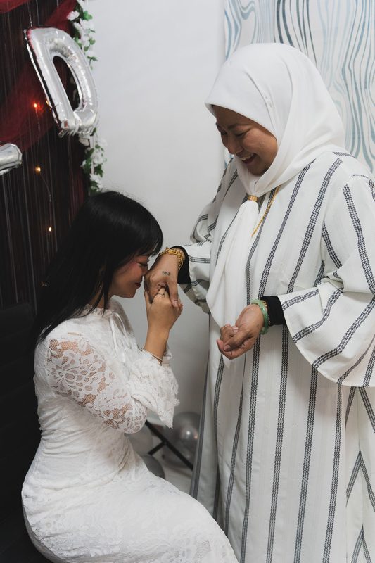 Kissing her mother's hand in blessing