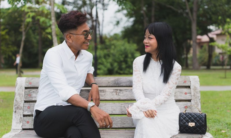 On a park bench, turned toward each other