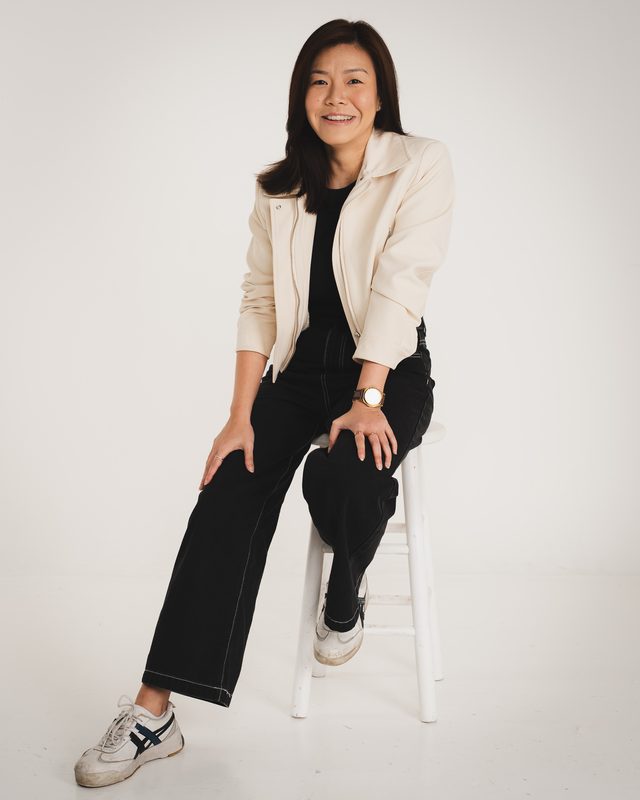 Wylie on a stool against a cream backdrop, smiling