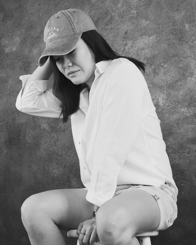 Wylie in a cap with a hand on her head, black and white
