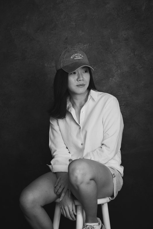 Wylie in a cap seated on a stool, black and white